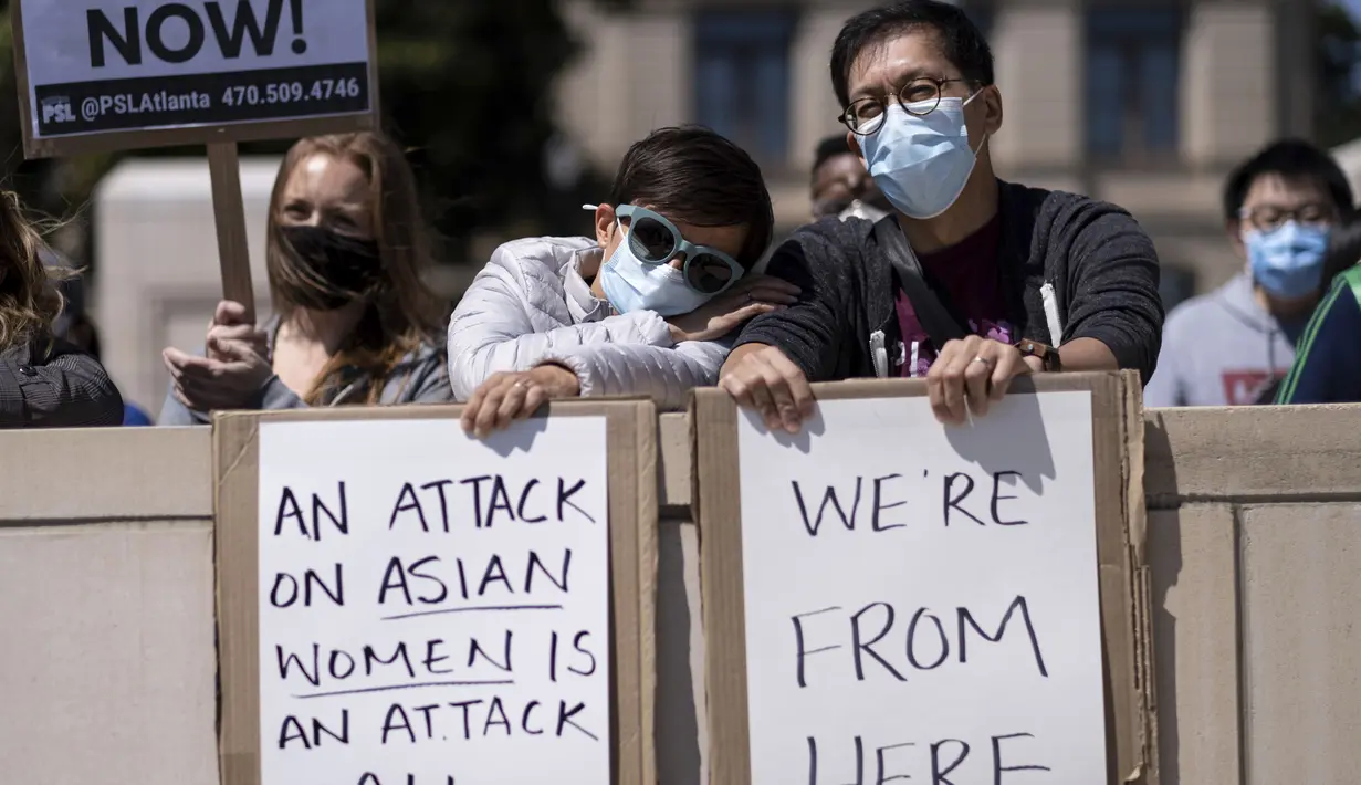 Agata Rozga dan Rich Vuduc berpartisipasi dalam unjuk rasa "Stop Asian Hate" di luar Gedung Kongres Georgia di Atlanta, Sabtu (20/3/2021). Ratusan demonstran berkumpul mendukung komunitas Asia-Amerika setelah penembakan tempat spa yang menewaskan 8 orang, termasuk 6 wanita Asia. (AP Photo/Ben Gray)
