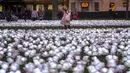 Seorang perempuan melihat bunga mawar putih yang menyala dalam instalasi yang dijuluki Ever After Garden di Grosvenor Square, London, Jumat, 15 Desember 2023. (AP Photo/Vadim Ghirda)