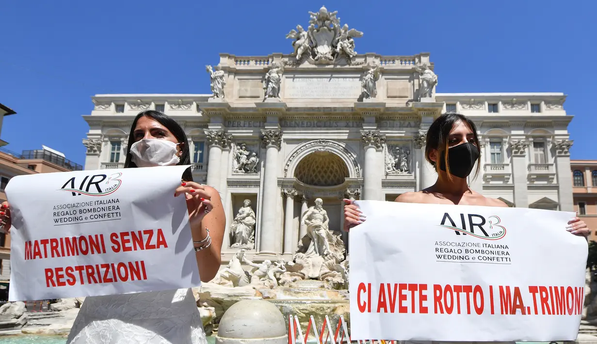 Pengantin perempuan yang mengenakan gaun pernikahan mereka melakukan protes dengan flashmob di Trevi Fountain, Roma, Selasa (7/7/2020). Mereka memprotes kebijakan pemerintah Italia yang masih melarang adanya acara pernikahan, meski penerapan lockdown sudah dilonggarkan. (Tiziana FABI/AFP)