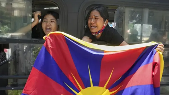 Warga Tibet di pengasingan meneriakkan slogan dari dalam bus setelah ditahan dan dibawa ke kantor polisi saat menggelar protes di New Delhi atas kunjungan Menteri Luar Negeri China Wang Yi ke India, Selasa (19/8/2025).