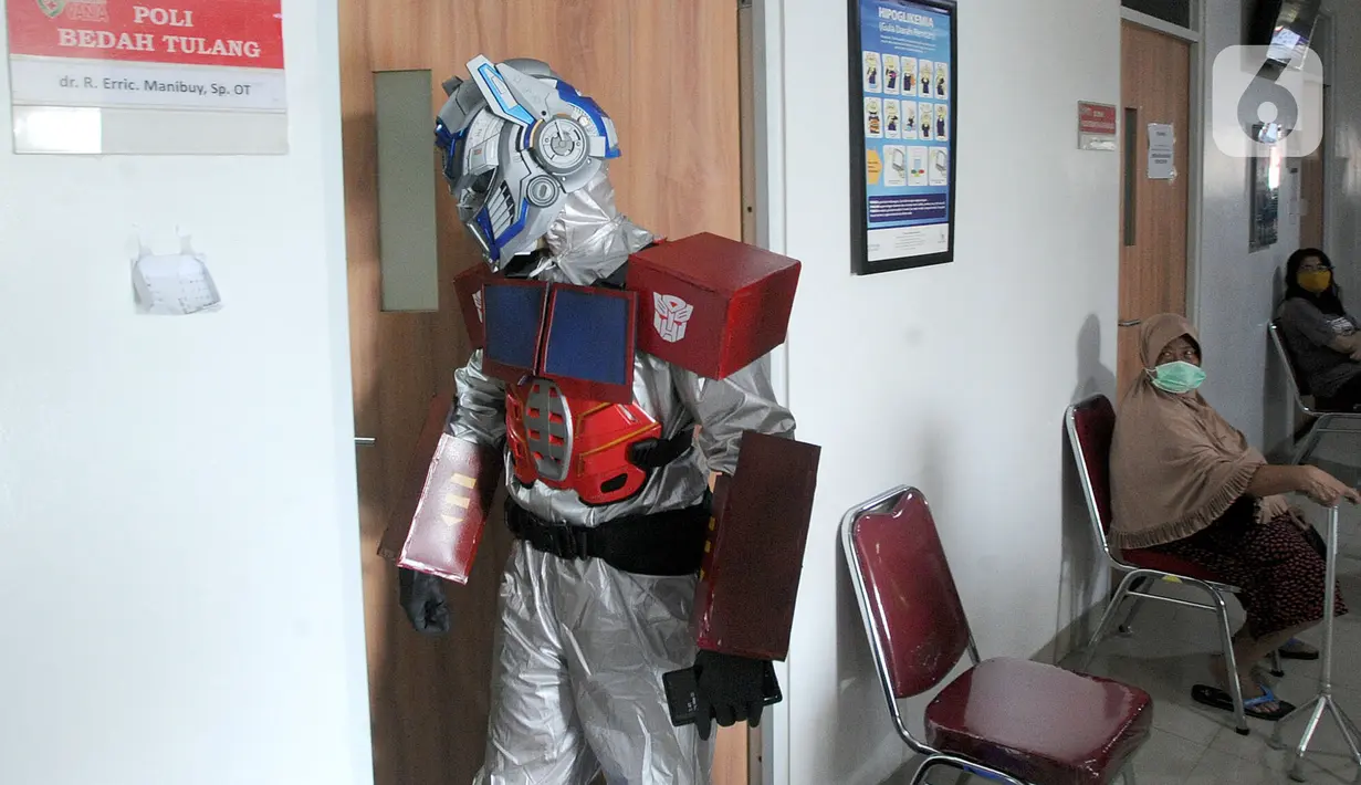 Dokter Rollando Erric Manibuy SpOT mengenakan alat pelindung diri (APD) ala transformer saat berada di RS Vania, Bogor, Jawa Barat, Jumat (22/5/2020). Penggunaan APD unik sejak merebaknya COVID-19 tersebut agar pasien tetap optimis meski sedang dalam pandemi. (merdeka.com/Arie Basuki)