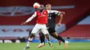 Striker Arsenal,Alexandre Lacazette, berebut bola dengan gelandang Liverpool, Fabinho, pada pada laga lanjutan Premier League pekan ke-36 di Emirates Stadium, Kamis (16/7/2020) dini hari WIB. Arsenal menang 2-1 atas Liverpool. (AFP/Glyn Kirk/pool)