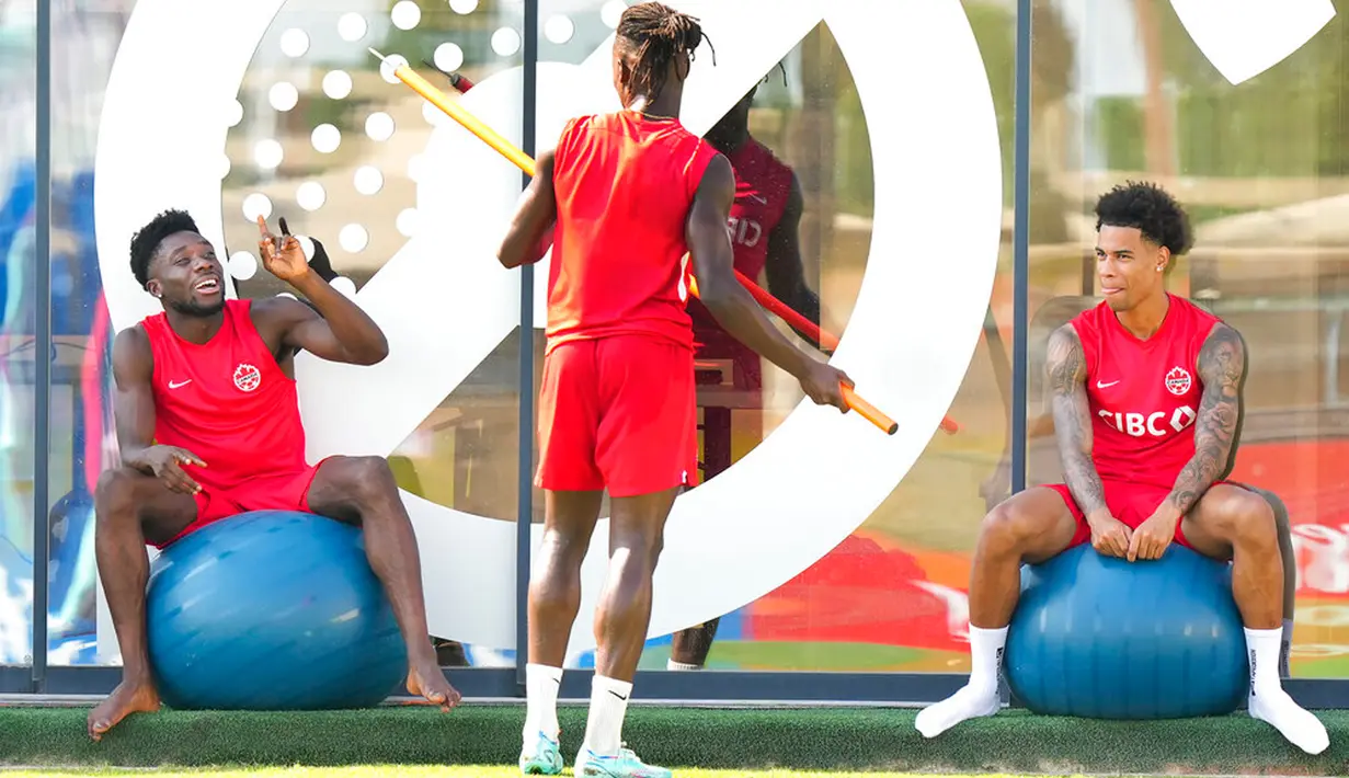 Pemain Kanada Alphonso Davies (kiri), Sam Adekugbe (tengah), dan Tajon Buchanan bercanda saat sesi latihan di Doha, Qatar, 28 November 2022. Kanada akan menghadapi Maroko dalam pertandingan Piala Dunia 2022 pada 1 Desember 2022. (Nathan Denette/The Canadian Press via AP)