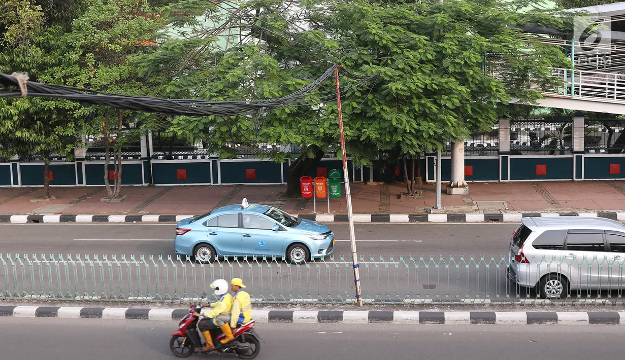 Tiang bambu menyangga instalasi kabel di kawasan Pasar Baru, Jakarta, Selasa (12/9). Selain membahayakan pengguna jalan, buruknya instalasi kabel tersebut juga merusak estetika kota. (Liputan6.com/Immanuel Antonius)