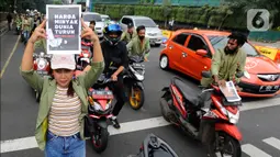 Seorang mahasiswi mengangkat sebuah poster bertuliskan “Harga Minyak Dunia Turun, bbm kok naik?”. Puluhan Mahasiswa Universitas Djuanda melakukan aksi tolak kenaikan harga bahan bakar minyak (BBM) dengan mendorong motornya sekitar 3 km dari Tugu Kujang hingga pintu 3 Istana Bogor, Kota Bogor, Jawa Barat, Rabu (7/9/20222). (Merdeka.com/Arie Basuki)