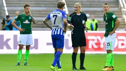 Wasit, Bibiana Steinhaus berdebat dengan gelandang Hertha Berlin, Alexander Esswein dan gelandang Werder Bremen, Maximilian Eggestein saat pertandingan Bundesliga Jerman di Berlin (10/9). (AFP Photo/Tobias Schwarz)