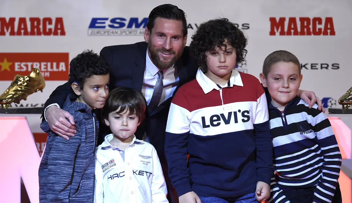 Striker Barcelona, Lionel Messi, foto bersama anak-anak saat menerima trofi Sepatu Emas Eropa di Antiga Fabrica Estrella Damm, Selasa, (18/12/2018). Messi berhak atas penghargaan itu berkat koleksi 34 gol dari 36 pertandingan. (AFP/Lluis Gene)