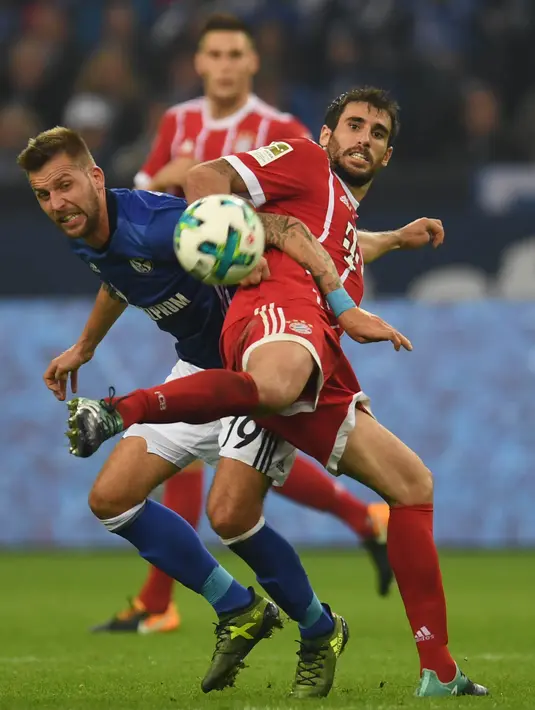 Gelandang Bayern Munchen, Javier Martinez, berebut bola dengan striker Schalke, Guido Burgstaller, pada laga Bundesliga, di Stadion Veltins, Selasa (20/9/2017). Bayern Munchen menang 3-0 atas Schalke. (AFP/Patrik Stollarz)