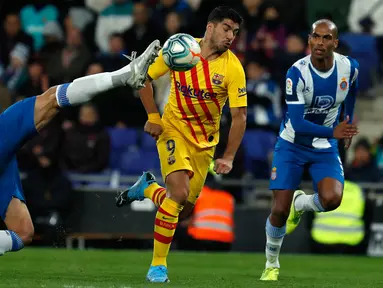 Pemain Espanyol, Bernardo Espinosa berebut bola dengan  Striker Barcelona, Luis Suarez pada pekan ke-19 La Liga di RCDE Stadium, Sabtu (4/1/2020). Hampir saja menang, Barcelona harus puas menerima hasil imbang 2-2 atas Espanyol. (AP/Joan Monfort)