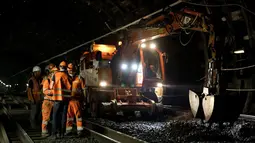 Sejumlah pekerja berdiskusi tentang pembuatan terowongan dan jalur baru kereta api antara Stasiun Charles de Gaulle-Etoile dan Auber, Paris (28/7/2015). Stasiun Charles de Gaulle-Etoile dibuka pada tanggal 1 September 1900. (AFP/KENZO TRIBOUILLARD)