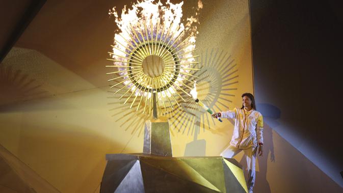 Peraih medali perak Olimpiade Cecilia Tait, dari Peru, menyalakan api Pan American selama Upacara Pembukaan di stadion Nasional di Lima, Peru (26/7/2019). Pan American Games XVIII diadakan dari 26 Juli hingga 11 Agustus 2019. (AP Photo/Martin Mejia)