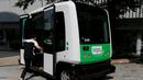 Seorang lelaki memasuki Robot Shuttle saat didemonstrasikan di Tokyo, Jepang, Kamis (7/7). Robot Shuttle adalah bus kemudi otomatis sehingga tak membutuhkan sopir untuk pengoperasiannya. (REUTERS / Toru Hanai)