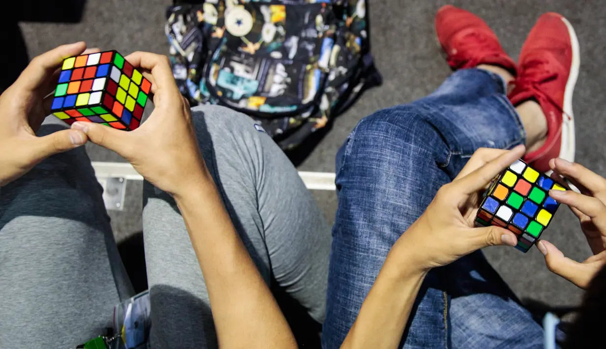 Peserta berlatih sebelum mengikuti kejuaraan kubus Rubik Dunia di Saint Denis, Paris, Prancis (16/7). Rubik sendiri adalah sebuah permainan yang mengasah kemampuan konsentrasi. (AFP Photo/Geoffroy Van Der Hasselt)