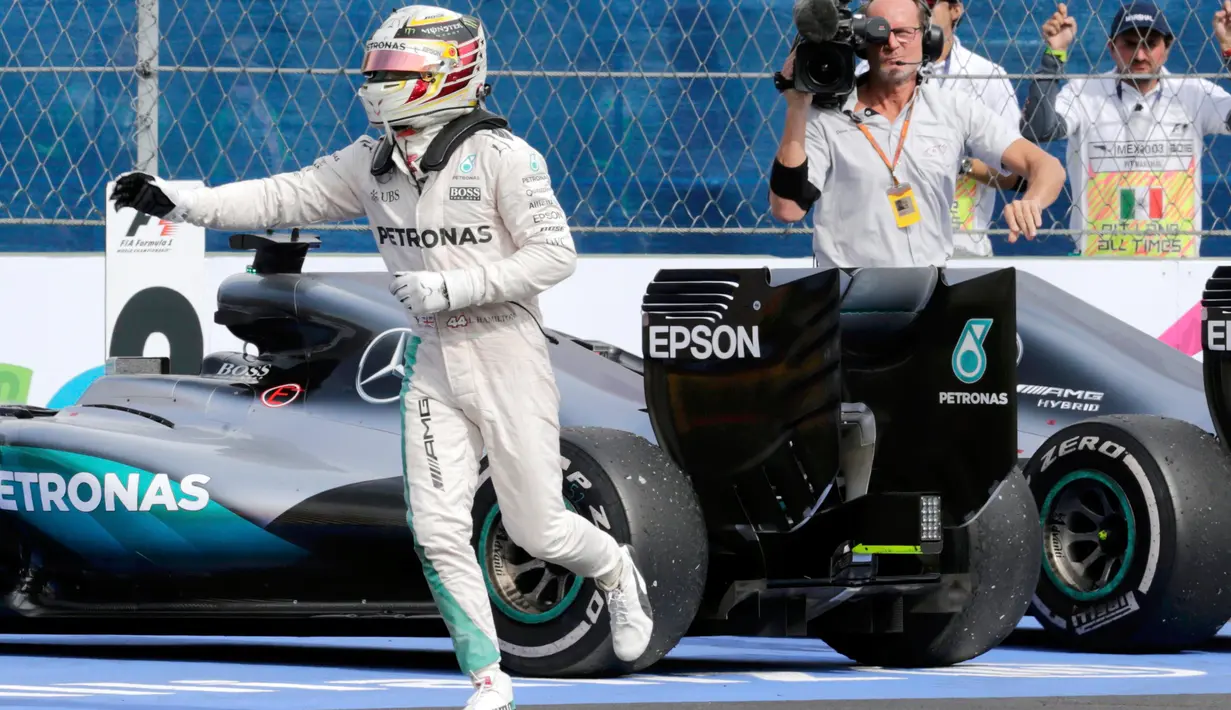 Pembalap tim Mercedes, Lewis Hamilton berlari setelah menyelesaikan balapan F1 Grand Prix Meksiko di Sirkuit Autodromo Hermanos Rodriguez, Meksiko (30/10). (Reuters/Henry Romero)