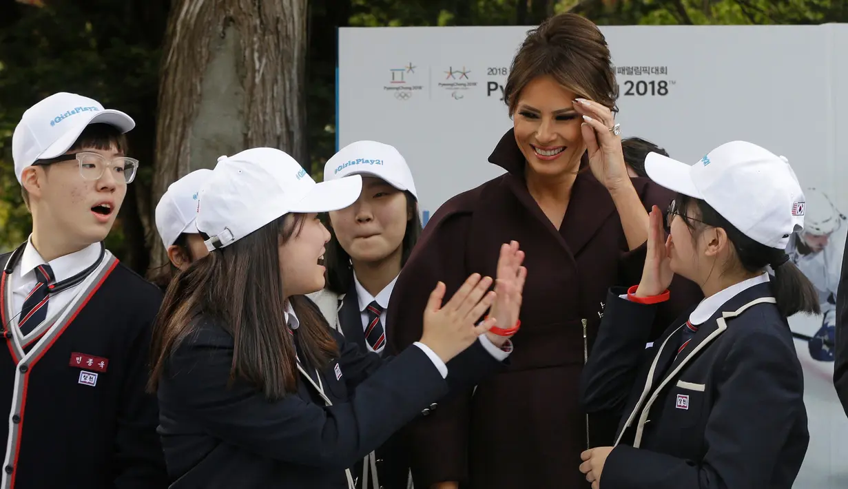 Ibu Negara AS, Melania Trump berfoto bersama para siswa SMA Korea Selatan selama acara 'Girls Play 2!' yang merupakan kampanye Olimpiade Musim Dingin PyeongChang 2018 di Kedutaan Besar AS di Seoul, Selasa (7/11). (AP Photo/Ahn Young-joon. Pool)