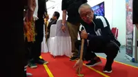 Deputi III Pembudayaan Olahraga Kemenpora, Raden Isnanta saat mencoba olahraga tradisional Balogo di Pameran Haornas (istimewa)