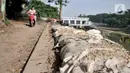 Kondisi karung berisi pasir untuk membatasi lokasi tanah longsor di pinggir Kanal Banjir Timur, Jakarta, Kamis (18/6/2020). Longsor yang terjadi pada awal Januari 2020 tersebut belum diperbaiki dan hanya ditutupi terpal besar guna mengantisipasi longsor susulan. (merdeka.com/Iqbal S. Nugroho)