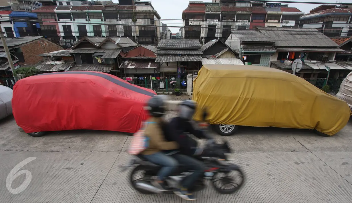 Pengendara motor melintas di jalur inspeksi Kanal Banjir Barat, Jakarta, Senin (6/3). Keterbatasan lahan menyebabkan sejumlah kendaraan parkir di tempat tersebut, meskipun telah terpampang larangan parkir. (Liputan6.com/Immanuel Antonius)