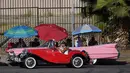 Sebuah kendaraan antik melewati mobil Lowrider yang diparkir di Sunset Boulevard, di lingkungan Echo Park, Los Angeles, pada 18 Juli 2021. Lowrider merupakan gaya dari kendaraan modifikasi yang bermula dari Los Angeles pada pertengahan hingga akhir 1940-an. (AP Photo/Damian Dovarganes)