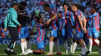 Bek Crystal Palace asal Prancis #05, Maxence Lacroix (tengah), dan gelandang Crystal Palace asal Jepang #18, Daichi Kamada (tengah kanan), merayakan kemenangan bersama rekan satu timnya setelah pertandingan final Piala FA Inggris antara Crystal Palace dan Manchester City di Stadion Wembley, London, pada 17 Mei 2025. Palace menang 1-0. (Adrian Dennis/AFP)