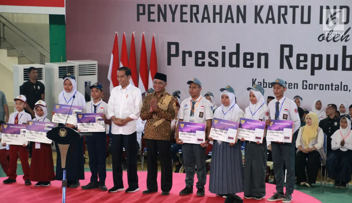 Presiden Joko Widodo atau Jokowi, Mendikbud Muhajir Effendy, dan perwakilan siswa-siswi SD, SMP, SMA se Provinsi Gorontalo foto bersama pada acara penyerahan Kartu Indonesia Pintar (KIP) di Gorontalo, Jumat (1/3). (Liputan6.com/Arfandi Ibrahim)