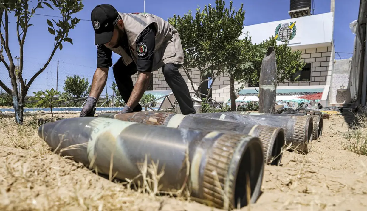 Seorang ahli bahan peledak Hamas menunjukkan proyektil yang tidak meledak setelah konflik Mei 2021 dengan Israel di kantor polisi setempat di Khan Yunis, Jalur Gaza, Sabtu (5/6/2021). Perang 11 hari antara Hamas dan Israel menewaskan 254 orang Palestina dan 12 orang Israel. (MAHMUD HAMS/AFP)