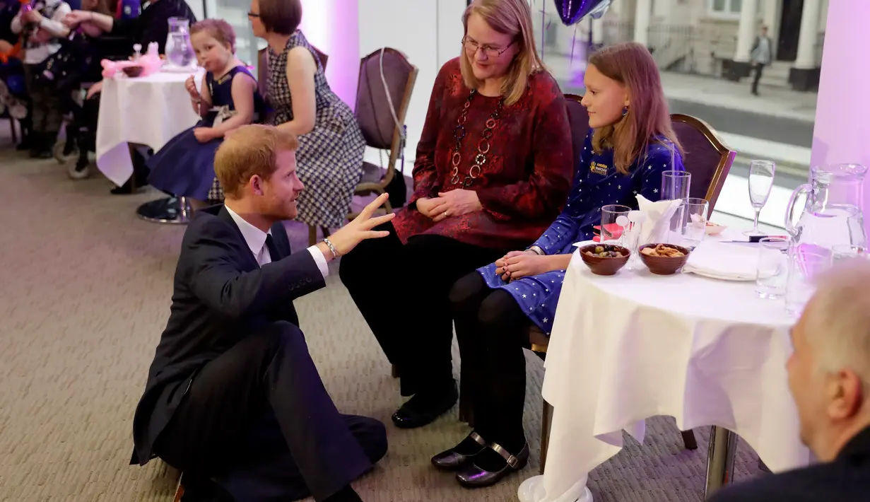 Pangeran Harry duduk dilantai saat berbincang dengan pemenang Penghargaan Anak Inspirasional berusia 11-14 tahun, Sasha Burrell saat menghadiri WellChild Awards di London, Inggirs (16/10). (AFP Photo/Pool/Matt Dunham)