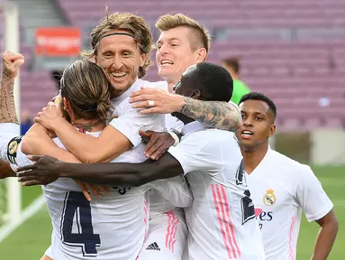Pemain Real Madrid merayakan gol yang dicetak Luka Modric ke gawang Barcelona pada laga Liga Spanyol di Camp Nou Stadion, Sabtu (24/10/2020) malam WIB. Real Madrid menang 3-1 atas Barcelona. (AFP/Lluis Gene)