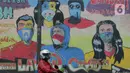 Seorang pengendara motor melewati mural anjuran kebiasan hidup baru dengan 3 M di Stasiun Cawang, Jakarta, Sabtu (26/12/2020). Pemerintah terus berupaya melakukan imbauan kepada warga untuk melaksanakan kebiasaan baru 3M guna memutus penyebaran virus corona (COVID-19). (merdeka.com/Imam Buhori)