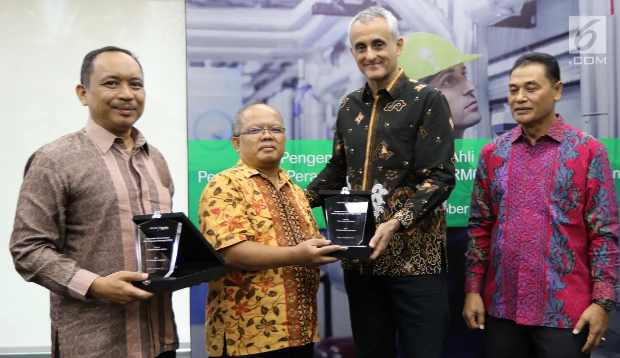 Country President Schneider Electric Indonesia, Xavier Denoly memberikan plakat kepada perwakilan Universitas Indonesia di Jakarta, Kamis (26/10). Schneider Electric donasikan 60 unit RM6 untuk 30 universitas dan politeknik. (Liputan6.com/Fery Pradolo)