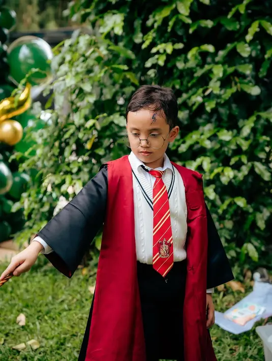 Xabiru, yang menjadi bintang utama dalam acara ini, tampil mengenakan jubah hitam Gryffindor lengkap dengan dasi merah-emas yang ikonik. Penampilannya semakin sempurna dengan tambahan kacamata bulat dan coretan luka petir di dahinya, mirip seperti karakter Harry Potter. Wajah serius namun menggemaskan Xabiru membuatnya benar-benar terlihat seperti penyihir kecil. [@vienstasman]