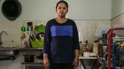 Ibu tunggal Tilda Kalaivani berpose di apartemen sewaannya di Kuala Lumpur pada 6 Juli 2021. Ketika Malaysia memerangi pandemi corona yang memburuk, semakin banyak keluarga berpenghasilan rendah yang berjuang dalam lockdown ketat mengibarkan bendera putih untuk memohon bantuan. (Mohd RASFAN/AFP)
