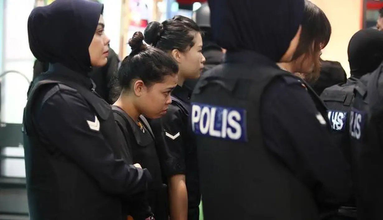 Tersangka kasus pembunuhan Kim Jong-nam, Siti Aisyah dengan kawalan polisi dibawa menuju Bandara Internasional Kuala Lumpur, Selasa (24/10). Siti terlihat mengenakan rompi anti-peluru saat mengunjungi tempat kejadian perkara itu. (AP/Sadiq Asyraf)