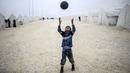 Bocah Syria bermain sepak bola di kamp pengungsian di Suruc, Propinsi Sanliurfa. (AFP PHOTO / BULENT KILIC)