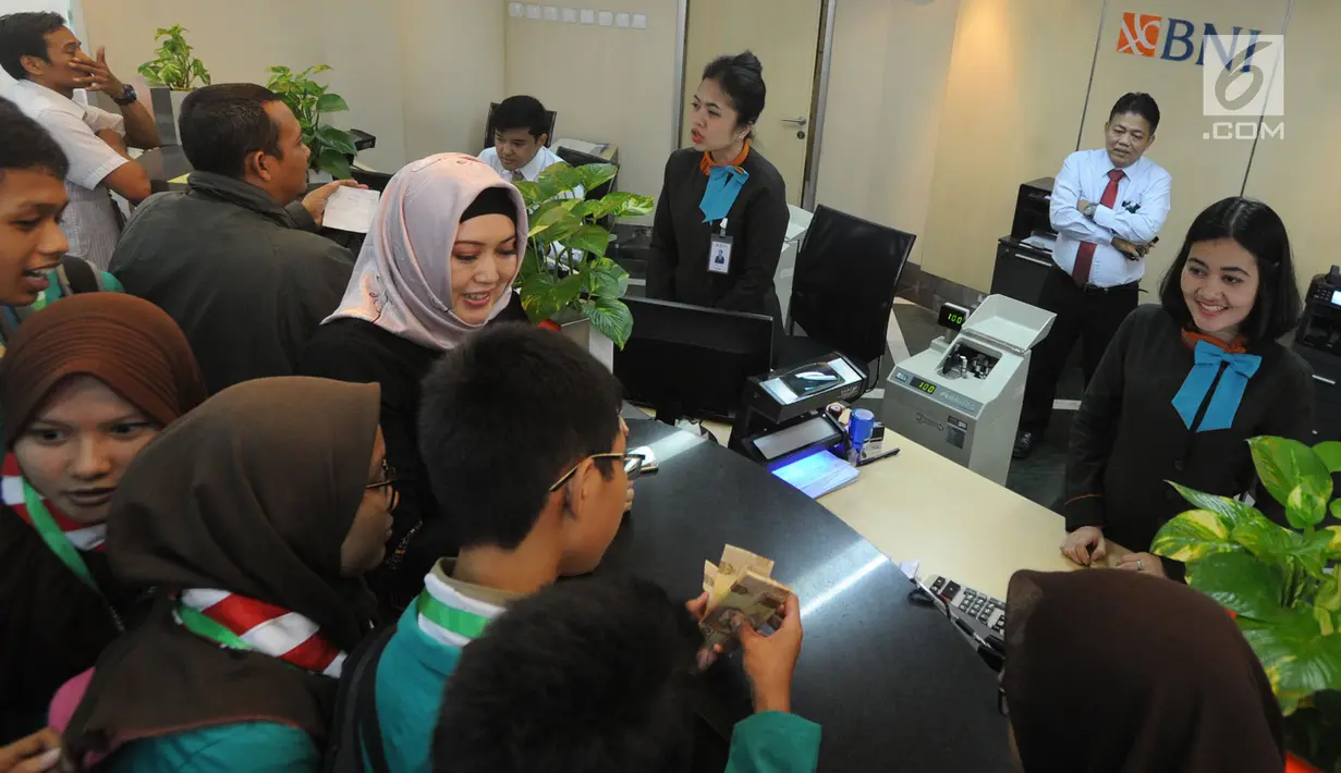 Sejumlah murid SMPN 141 menjajal menghitung uang saaat mengunjungi BNI Kantor Cabang Tebet, Jakarta (2/5). Kegiatan ini untuk mengenal lebih dekat kegiatan perbankan di lingkungan operasional  BNI Cabang Tebet. (Merdeka.com/Arie Basuki)
