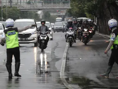 Polisi memberhentikan pengendara motor yang melanggar aturan pada jalur kiri khusus sepeda motor di Jalan MH Thamrin-Medan Merdeka Barat, Jakarta Pusat, Kamis (8/2). (Liputan6.com/Arya Manggala)