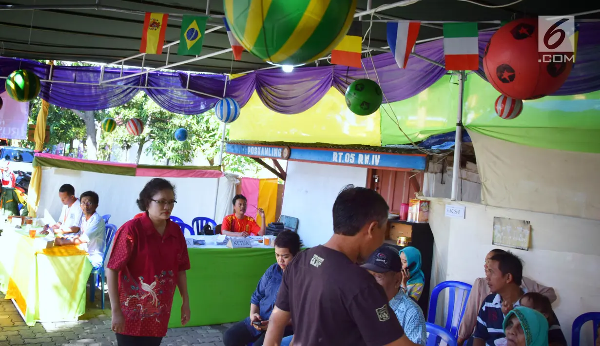 Aktivitas pemilihan suara Pilkada Serentak 2018 di TPS 7 Kelurahan Bulu Lor, Semarang. Rabu (27/6). TPS ini dihiasi ornamen Piala Dunia, dengan memasang bendera peserta Piala Dunia di Rusia serta petugas KPPS yang mengenakan jersey. (Liputan6.com/Gholib)