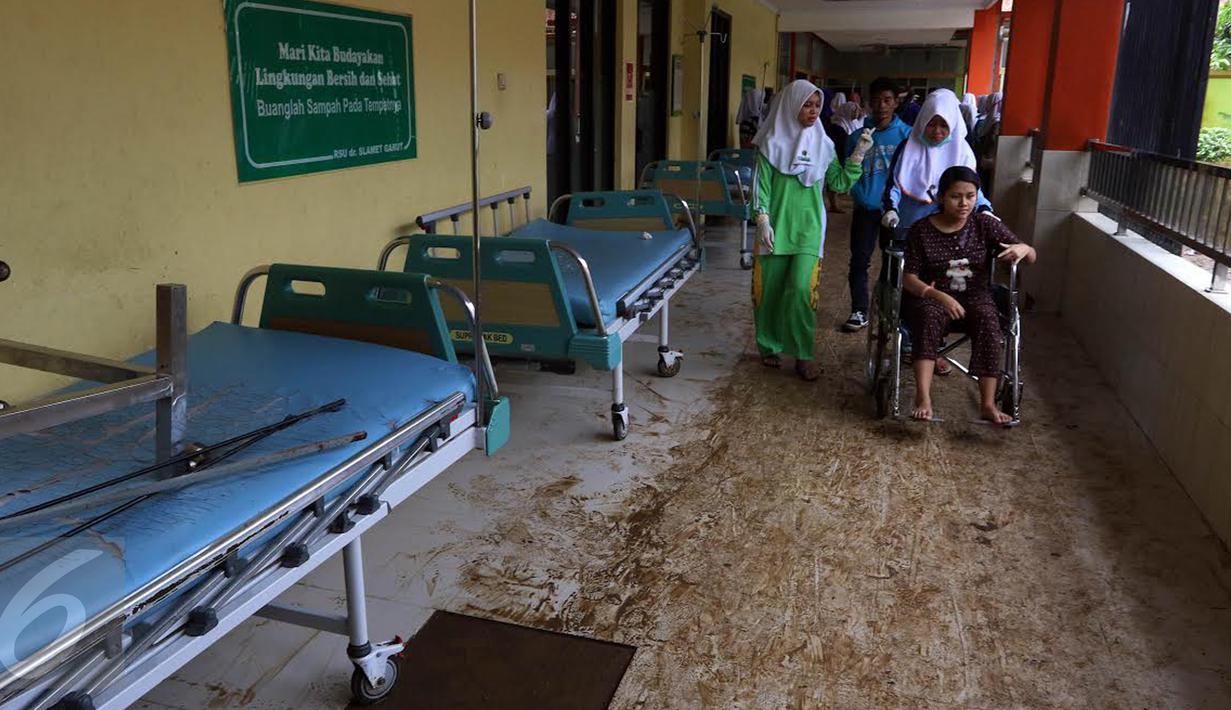 Pasien melintas di koridor RSUD dr Slamet setelah terjangan banjir bandang dari aliran sungai Cimanuk di Kabupaten Garut, Kamis (22/9). Usai diterjang banjir bandang pada Rabu (21/9), RSUD dr Slamet Garut masih belum beroperasi. (Liputan6.com/Johan Tallo)