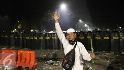 Seorang pendemo mencegah kawannya untuk menyerang polisi saat Aksi Damai 4 November, Jakarta, Jumat (4/11). Bentrok terjadi usai polisi membubarkan paksa dengan gas air mata. (Liputan6.com/Faizal Fanani)