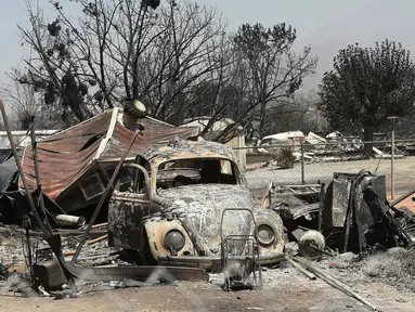 Sebuah mobil Volkswagen Beetle yang berada di antara puing-puing rumah terlihat hangus terbakar di perkampungan Erskine setelah kebakaran hebat melahap lahan di sepanjang South Lake, California, AS (24/6). (REUTERS/Noah Berger)