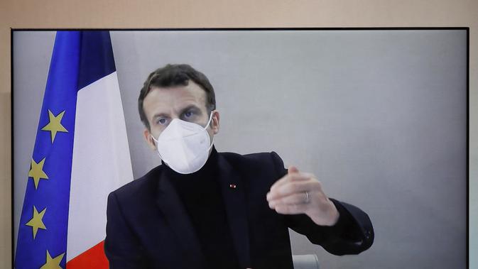 Presiden Prancis Emmanuel Macron terlihat di layar saat dia menghadiri konferensi Kemanusiaan Nasional (NHC), di Kementerian Luar Negeri di Paris, Kamis (17/12/2020). Prancis saat ini melakukan pembatasan sosial ketat seiring datangnya musim dingin. (Charles Platiau/Pool via AP)