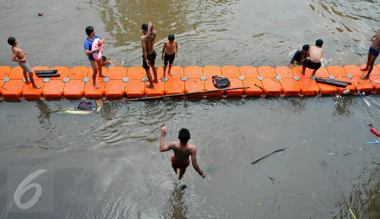 Anak-anak bantaran Sungai Ciliwung bermain dan berenang di aliran Sungai Ciliwung, Jakarta, Rabu (18/5/2016).Kondisi air sungai Ciliwung saat ini lebih bersih dari tumpukan sampah. (Liputan6.com/Yoppy Renato)