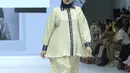 Tya Ariestya tampil percaya diri sebagai muse dalam kolaborasi ini, mengenakan kerudung navy blue yang dipadukan dengan kemeja bermotif pleated hijau yang dihiasi list kerang, lengan, dan kancing berwarna biru. Kemeja tersebut selaras dengan celana flare pleated yang dikenakannya. [Dok/Fimela/Adrian Utama P].