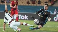 Penyerang timnas Portugal, Andre Silva dan kiper Belgia, Thibaut Courtois berebut bola babak 16 besar Euro 2020 di Estadio La Cartuja, Sevilla, Spanyol, Senin (28/6/2021) dini hari WIB. Belgia mendepak juara bertahan Portugal berkat kemenangan 1-0. (AP Photo/Thanassis Stavrakis, Pool)