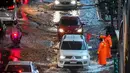 Petugas keamanan mengatur lalu lintas di jalan yang banjir saat hujan deras di Bangkok (23/9/2020). (AFP/Mladen Antonov)