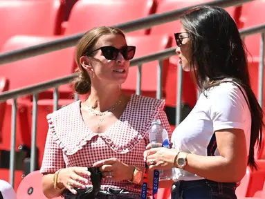 Annie Kilner, tunangan pemain Inggris Kyle Walker (kanan) berbincang Coleen Rooney, istri mantan pemain Inggris Wayne Rooney pada grup D Euro 2020 antara Inggris melawan Kroasia di stadion Wembley, London (13/6/2021). Annie tampil mengenakan jersey Inggris dan kacamata hitam. (AFP/Pool/Glyn Kirk)