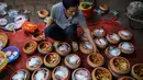Seorang pria menyiapkan ikan gurame dan bahan-bahan lain untuk dimasak di pot tanah liat menggunakan kayu bakar di provinsi Ha Nam, Vietnam, Selasa (21/1/2020). Ikan rebus adalah makanan lezat populer untuk Tahun Baru Imlek atau dikenal dengan nama Tet di utara Vietnam. (Nhac NGUYEN / AFP)