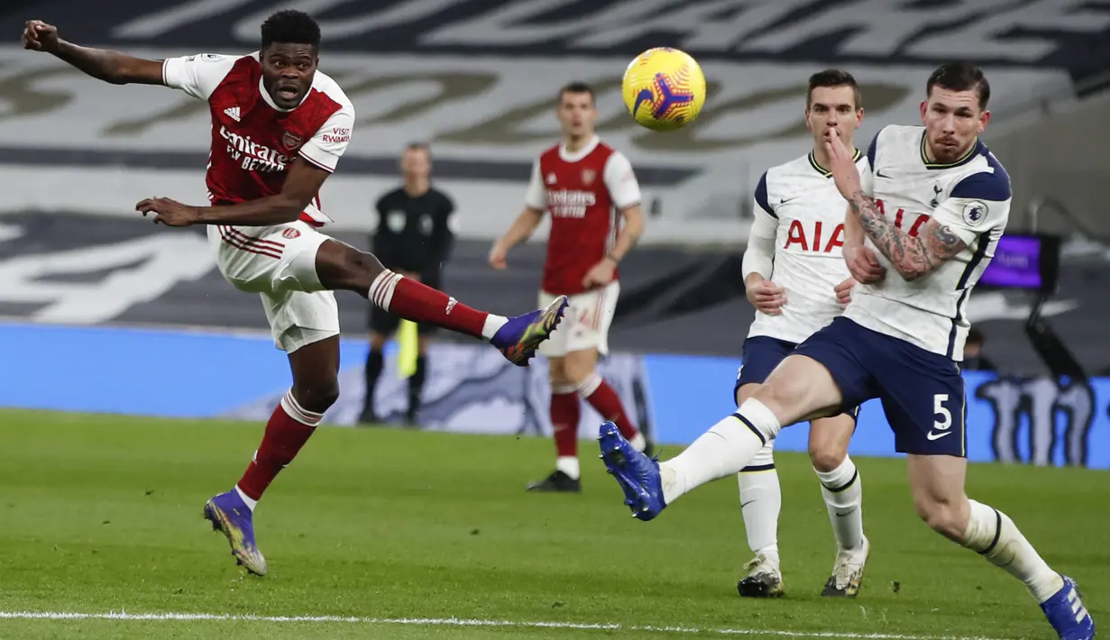 Gelandang Arsenal, Thomas Partey menembak bola dari kawalan bek Totttenham Hotspur, Emile Hojbjerg pada pertandingan lanjutan Liga Inggris di Tottenham Hotspur Stadium di London, Inggris , Minggu (7/12/2020). Tottenham menang 2-0. (Paul Childs/Pool via AP)