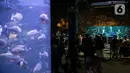 Pengunjung menyaksikan pertunjukan drama teatrikal bertajuk Rabbit Underwater Show In Mission Save The Ocean di Sea World Ancol Jakarta, Selasa (30/3/2021). Pertunjukan digelar untuk mengedukasi warga dalam menjaga ekosistem laut dari sampah atau polusi laut. (Liputan6.com/Faizal Fanani)