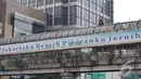 Agustinus terlihat duduk-duduk santai di atap jembatan penyeberangan orang itu. Bendera Merah Putih yang dibawanya diikatkan di besi-besi yang ada di jembatan tersebut, Jakarta, Rabu (23/07/2014) (Liputan6.com/Johan Tallo)